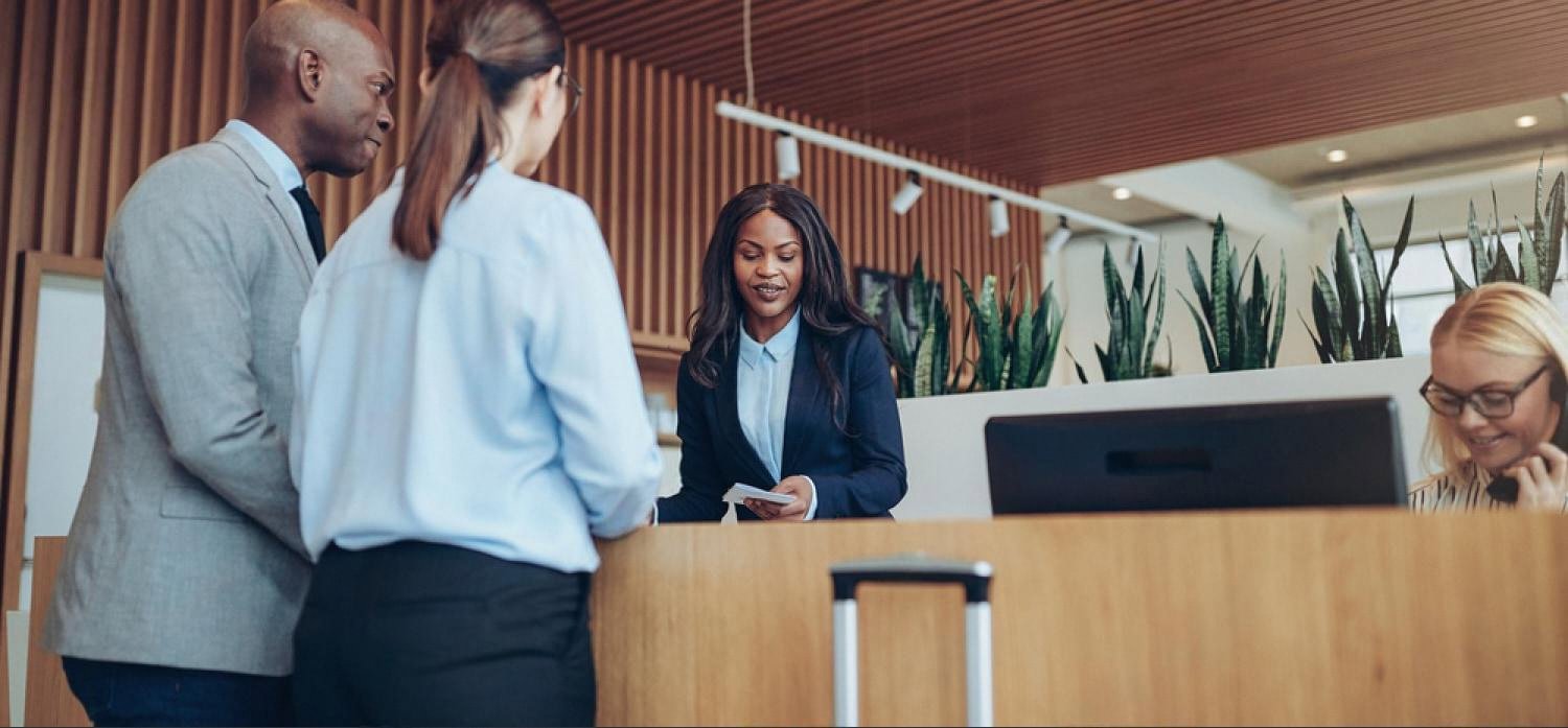 Two guests checking in at a busy hotel reception counter in Dubai